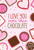 Funny Valentine's Day greeting card for her featuring a pink background with the playful text 'I LOVE YOU more than CHOCOLATE' surrounded by various heart-shaped and round chocolate-themed candies and cupcakes in shades of pink, red, white, and brown.