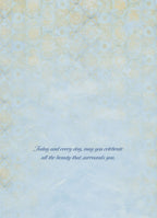 Inside view of a thoughtful greeting card with a delicate blue and gold patterned background. The message reads: 'Today and every day, may you celebrate all the beauty that surrounds you.'