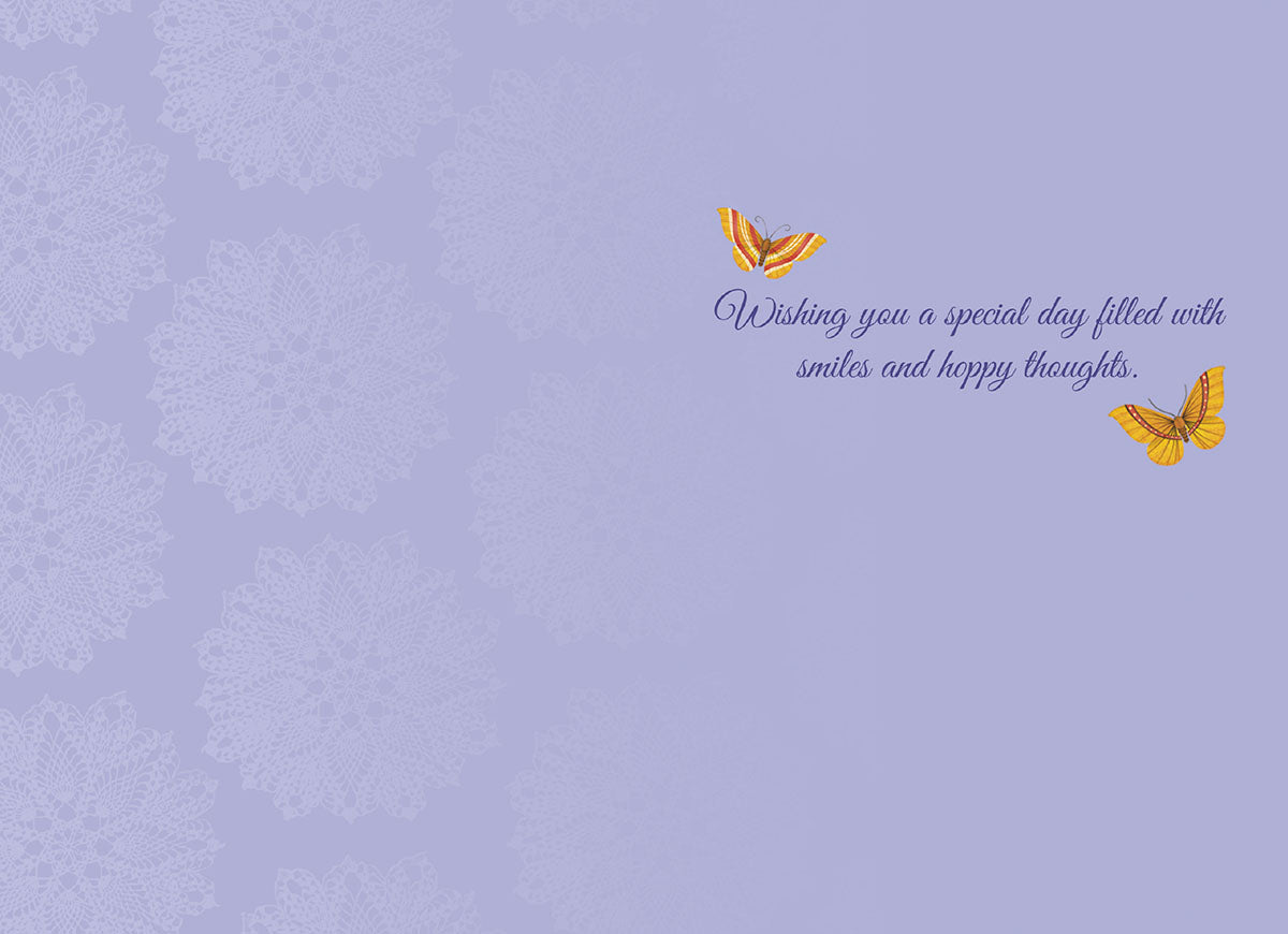 Inside of a cute birthday greeting card with a light lavender purple background featuring subtle mandala patterns. Two yellow butterflies flutter above elegant script text that reads: 'Wishing you a special day filled with smiles and hoppy thoughts.'
