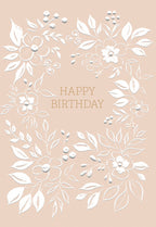 Elegant blush pink birthday greeting card with embossed white floral wreath design and gold 'HAPPY BIRTHDAY' lettering.