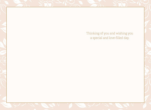 Open greeting card interior showing heartfelt message 'Thinking of you and wishing you a special and love-filled day.' with a delicate floral border on a cream background.