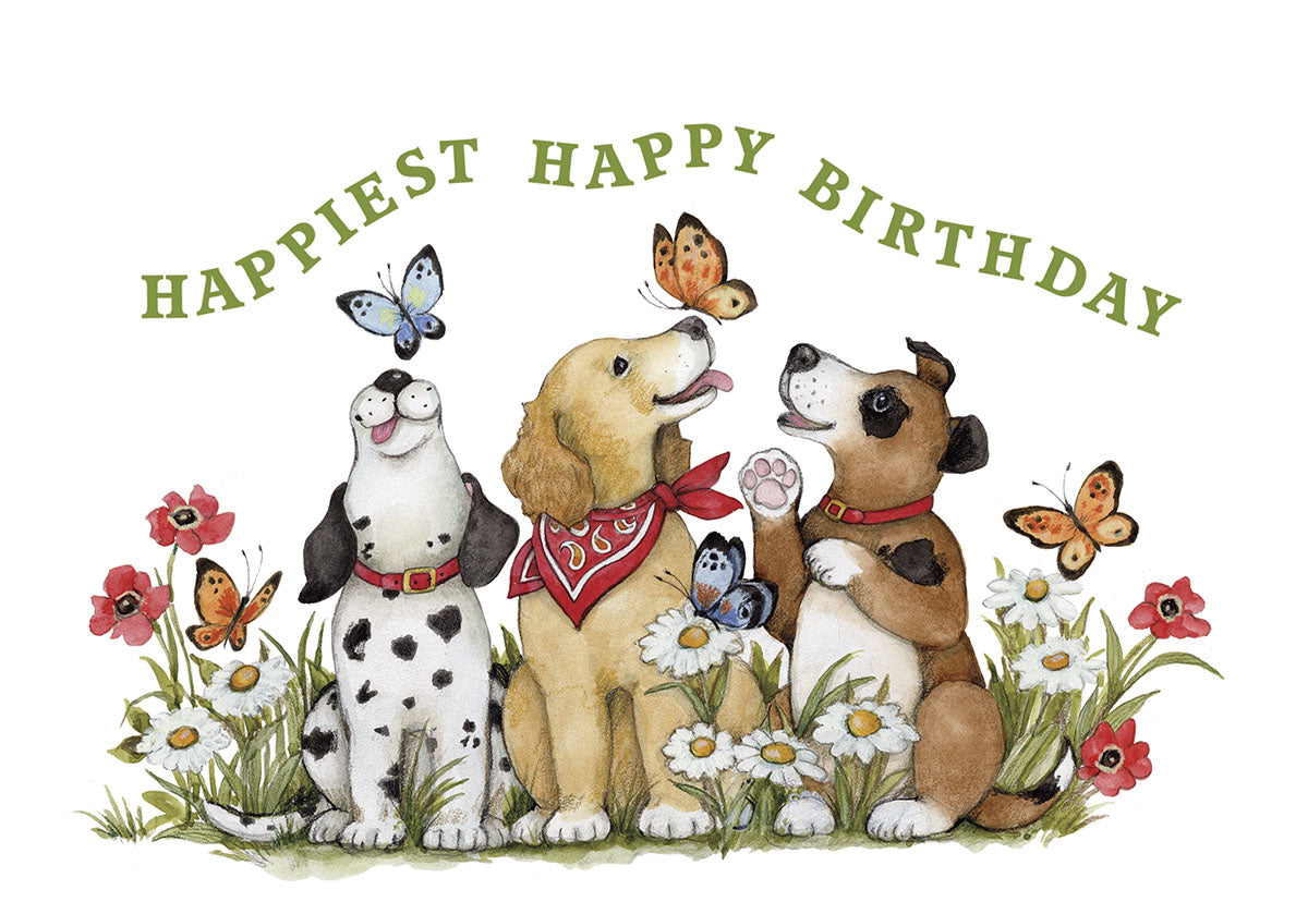 Front of a cute greeting card featuring three watercolor dogs (a white and black spotted dog, a golden retriever with a red bandana, and a brown and white dog) surrounded by colorful butterflies and wildflowers against a white background with the text 'HAPPIEST HAPPY BIRTHDAY' arched above.