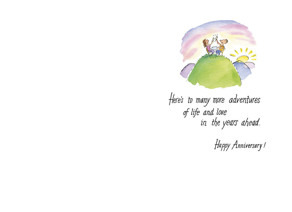 Inside of a heartwarming anniversary card, showing a couple sitting on a hill watching the sunset. The romantic message reads 'Here's to many more adventures of life and love in the years ahead. Happy Anniversary!' Designed for celebrating enduring love.