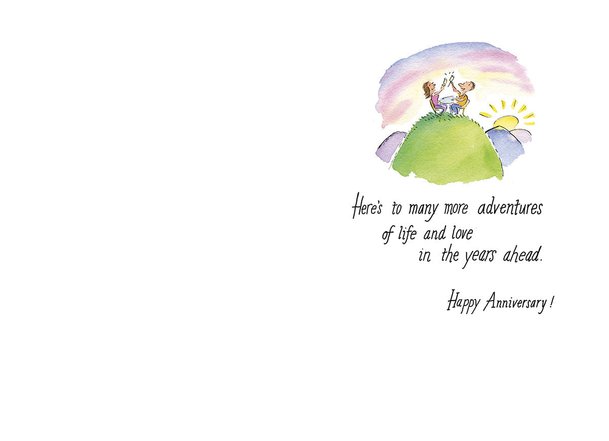 Inside of a heartwarming anniversary card, showing a couple sitting on a hill watching the sunset. The romantic message reads 'Here's to many more adventures of life and love in the years ahead. Happy Anniversary!' Designed for celebrating enduring love.