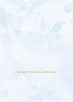 Inside view of an encouragement card with subtle blue floral watermark and gold text 'So sorry to hear your sad news.', offering heartfelt sympathy.