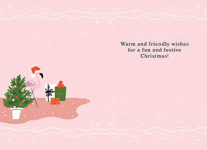Inside a pink Christmas card with a flamingo, tree, gifts, and festive message: Warm and friendly wishes for a fun and festive Christmas!