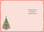 Inside of a holiday greeting card with a small decorative pine tree on the left and a warm message on the right: 'May your heart and home be decorated with all the joys of the season!'. The card has a soft pink background and a white scalloped border.