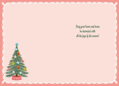 Inside of a Feliz Navidad card, featuring a small Christmas tree and the message: "May your heart and home be decorated with all the joys of the season!"