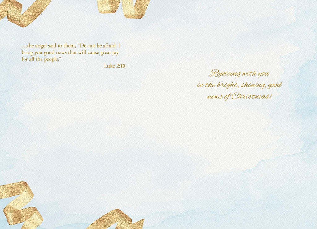 Inside view of a religious greeting card featuring a watercolor light blue background with golden ribbons, displaying Luke 2:10 scripture and the heartfelt message: 'Rejoicing with you in the bright, shining, good news of Christmas!'