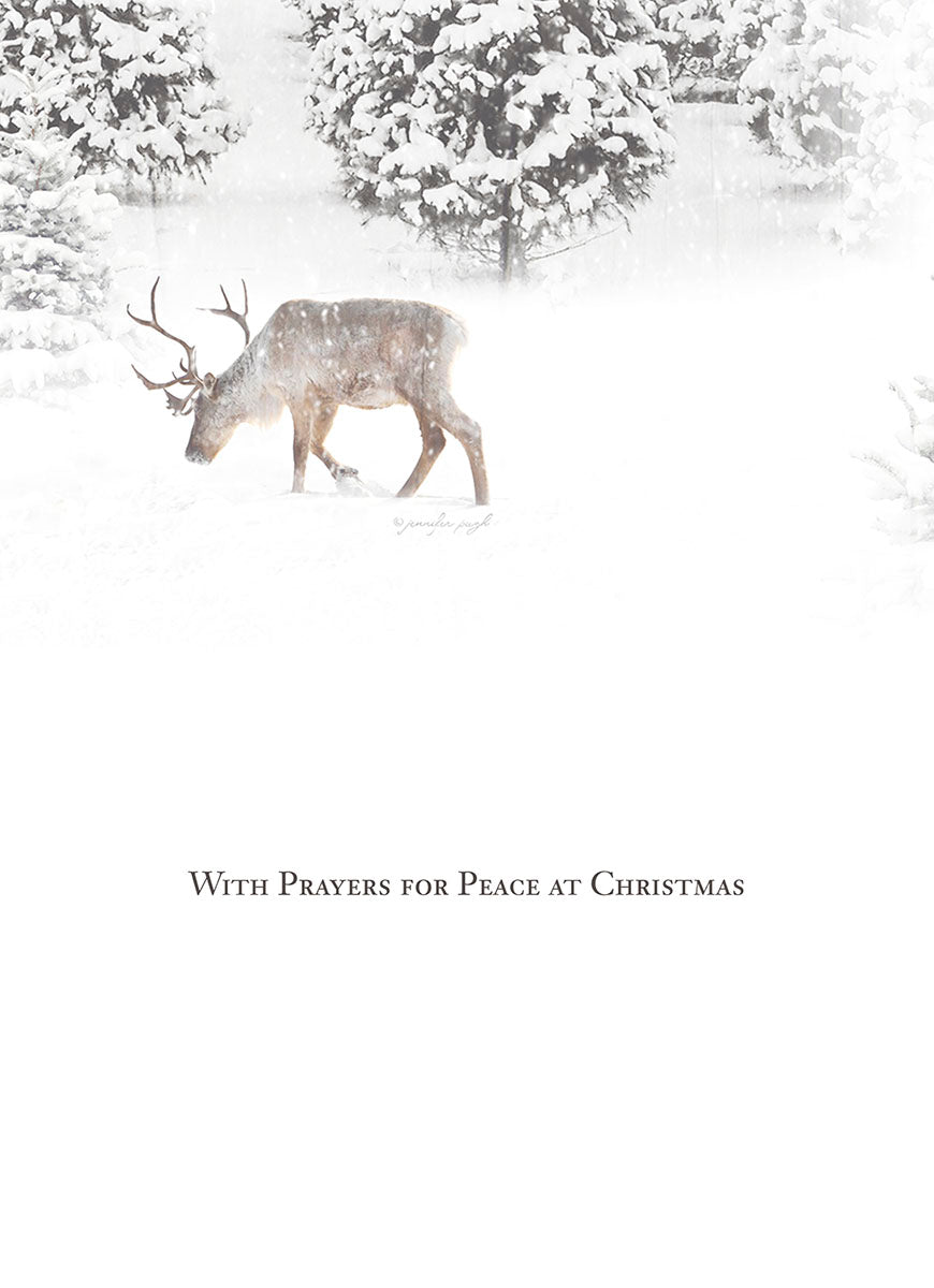 Inside of a religious Christmas card showing a reindeer walking in deep snow amidst snow-covered trees, with the message 'With Prayers for Peace at Christmas'.