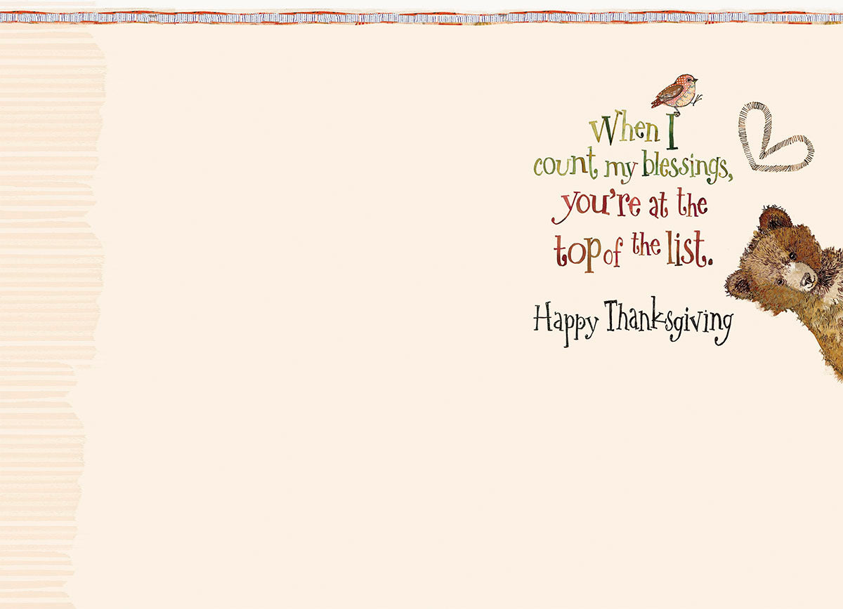 Inside view of a Thanksgiving greeting card showing warm sentiment: 'When I count my blessings, you're at the top of the list. Happy Thanksgiving.' A glimpse of the cute bear illustration is visible, adding to the charm.
