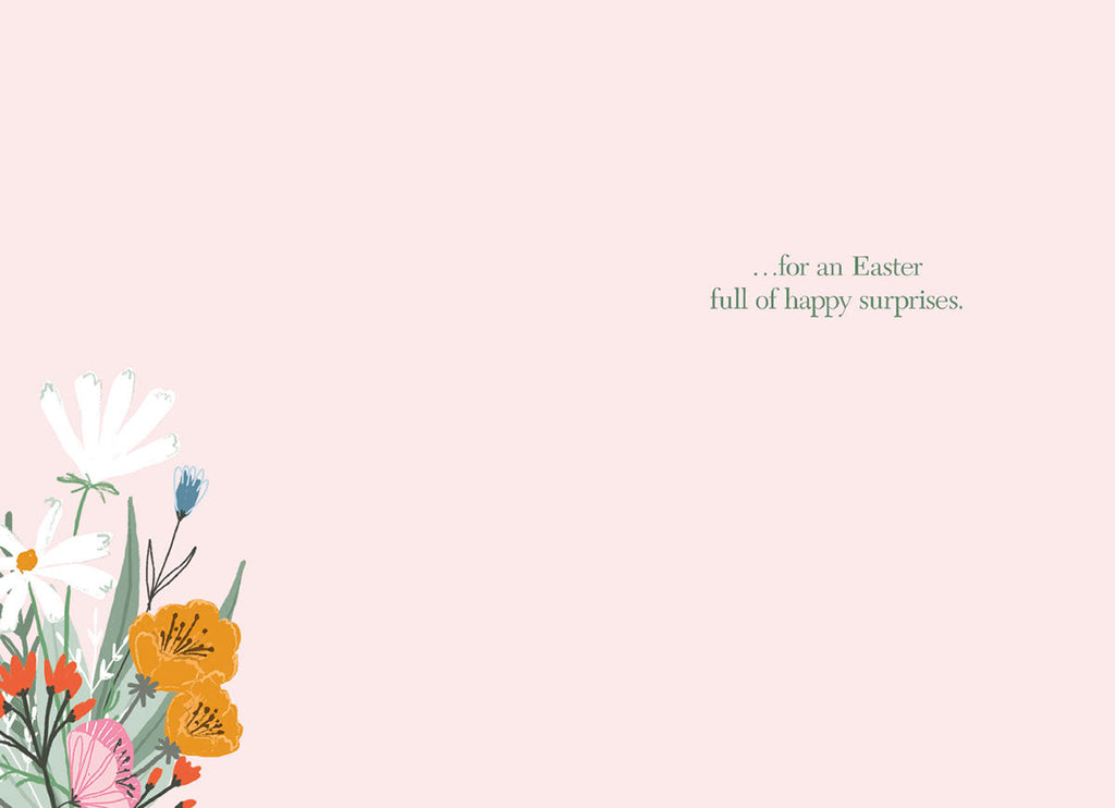 Interior of a greeting card with a small floral arrangement in the bottom left corner and the message '...for an Easter full of happy surprises.' in simple green text on a light pink background.