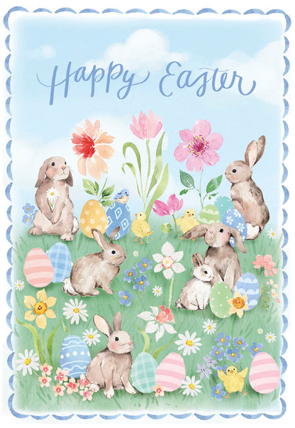 Front of a Happy Easter card with watercolor bunnies, chicks, eggs, and spring flowers in a green field under a blue sky.