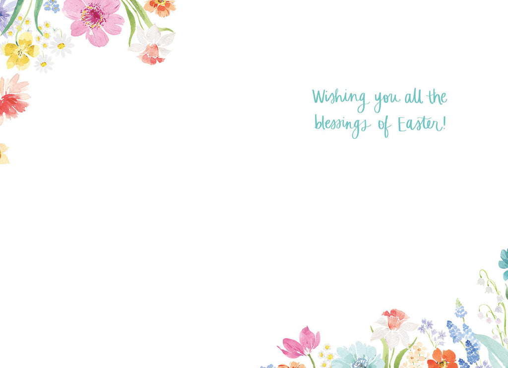 Inside of a white Easter greeting card with subtle watercolor floral corner accents, displaying the light blue handwritten text 'Wishing you all the blessings of Easter!'.
