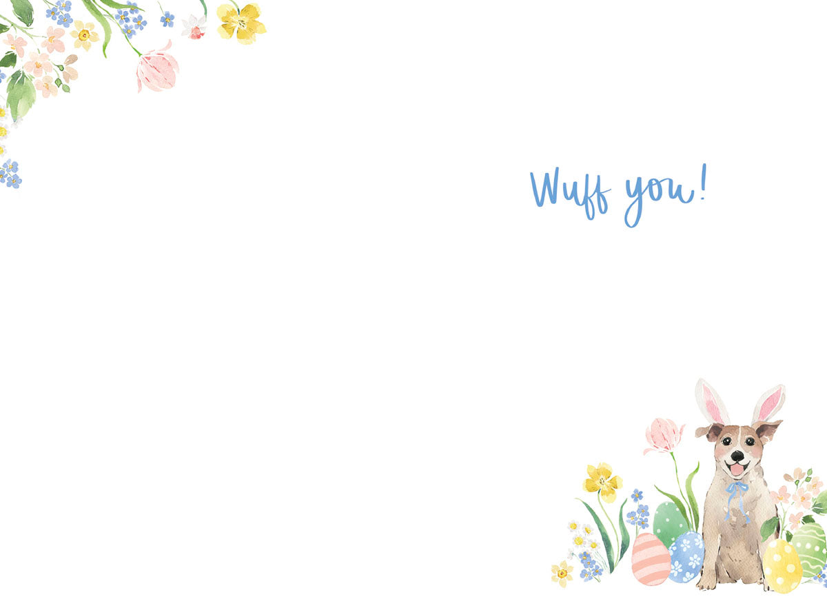 Inside view of an Easter greeting card with a minimalist design, featuring a small watercolor illustration of a dog with bunny ears, pastel eggs, and spring flowers in the bottom right corner. The card includes the playful handwritten message 'Wuff you!' in blue script on a white background, with additional floral accents in the top left corner.