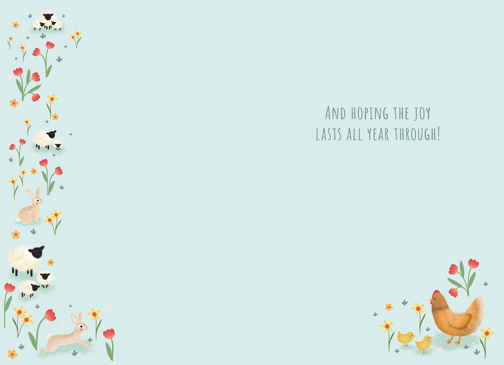 Inside of the greeting card with a light blue background. The left edge features a decorative vertical border of red tulips, yellow daffodils, white sheep, and bunnies. The bottom right corner shows a smaller cluster of a hen, two chicks, and flowers. Text reads: 'And HOPING THE JOY LASTS ALL YEAR THROUGH!'