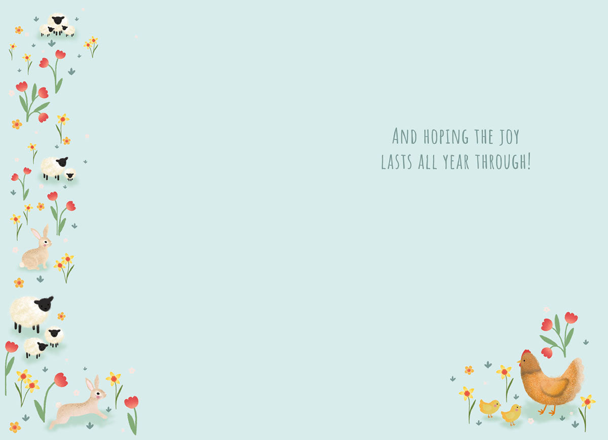 Inside of the greeting card with a light blue background. The left edge features a decorative vertical border of red tulips, yellow daffodils, white sheep, and bunnies. The bottom right corner shows a smaller cluster of a hen, two chicks, and flowers. Text reads: 'And HOPING THE JOY LASTS ALL YEAR THROUGH!'