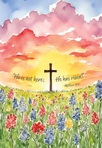 Religious greeting card featuring a watercolor sunrise with a cross silhouette, vibrant wildflowers, and Matthew 28:6 scripture for celebrating the resurrection.