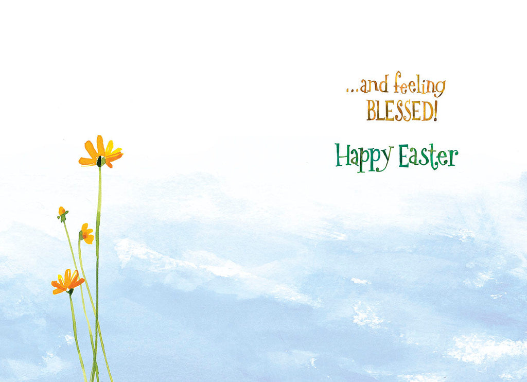 Inside of a religious greeting card showing a serene blue sky with a few yellow wildflowers and the inspiring text '...and feeling BLESSED! Happy Easter'.