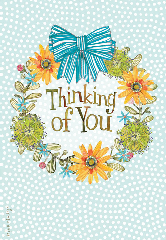Colorful 'Thinking of You' greeting card with a whimsical floral wreath, yellow and green flowers, and a blue striped bow on a polka dot background.