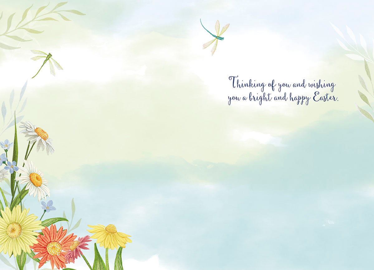 Inside of a lighthearted Easter greeting card with a watercolor sky background, delicate spring flowers, dragonflies, and the message 'Thinking of you and wishing you a bright and happy Easter.'