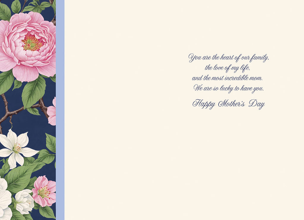 Open greeting card interior revealing a creamy white background with a matching floral border on the left side. The heartfelt gold script message reads: 'You are the heart of our family, the love of my life, and the most incredible mom. We are so lucky to have you. Happy Mother's Day'.