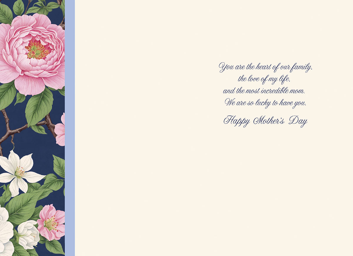 Open greeting card interior revealing a creamy white background with a matching floral border on the left side. The heartfelt gold script message reads: 'You are the heart of our family, the love of my life, and the most incredible mom. We are so lucky to have you. Happy Mother's Day'.