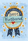 Father's Day greeting card front with a blue and gold award ribbon. The ribbon features a crown and text 'Happy Father's Day! Best Husband in the World' surrounded by sparkling gold stars on a light blue background.