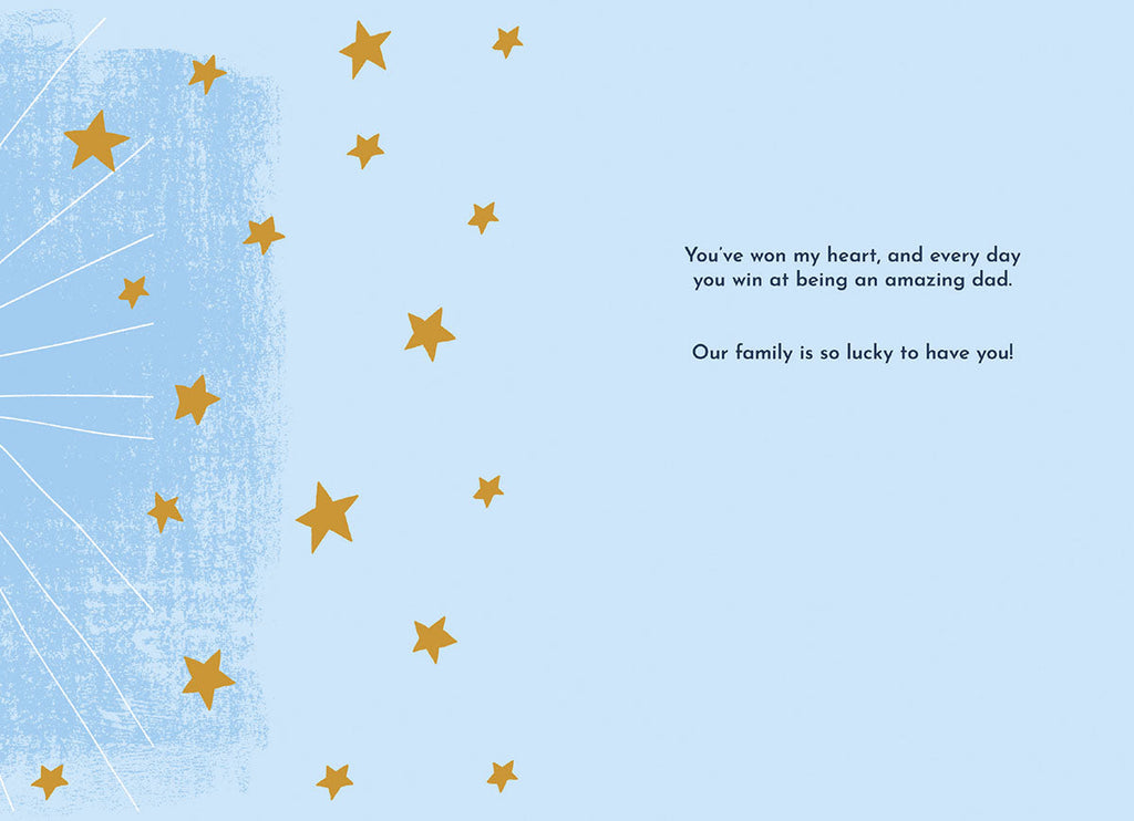 Inside of the Father's Day greeting card, showing a light blue background with scattered gold stars. The heartfelt message reads: 'You've won my heart, and every day you win at being an amazing dad. Our family is so lucky to have you!'