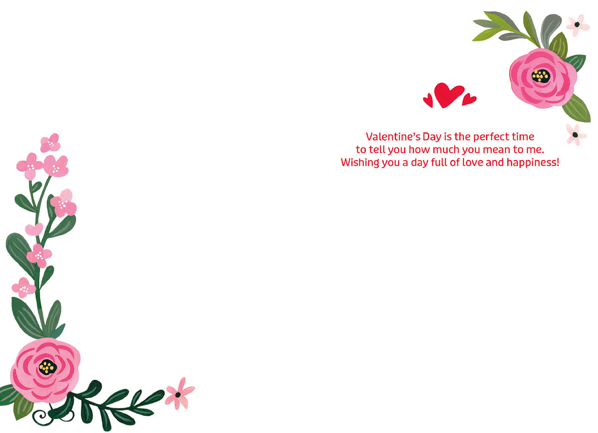 Inside of a Valentine's Day card with a pre-printed message 'Valentine's Day is the perfect time to tell you how much you mean to me. Wishing you a day full of love and happiness!' adorned with floral corners.