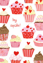 Vibrant Valentine's Day greeting card featuring an array of illustrated pink, red, and chocolate cupcakes adorned with hearts and cherries, with the playful text 'hey cupcake!' in script.