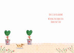 Inside of a romantic Valentine's Day greeting card, featuring a minimalist white background with two green heart-shaped topiary plants in gray pots tied with red ribbons. A small brown dog walks across the bottom, with the sweet message 'LOVE IS IN FULL BLOOM!' and 'WISHING YOU A BEAUTIFUL VALENTINE'S DAY' written in red cursive on the right side.