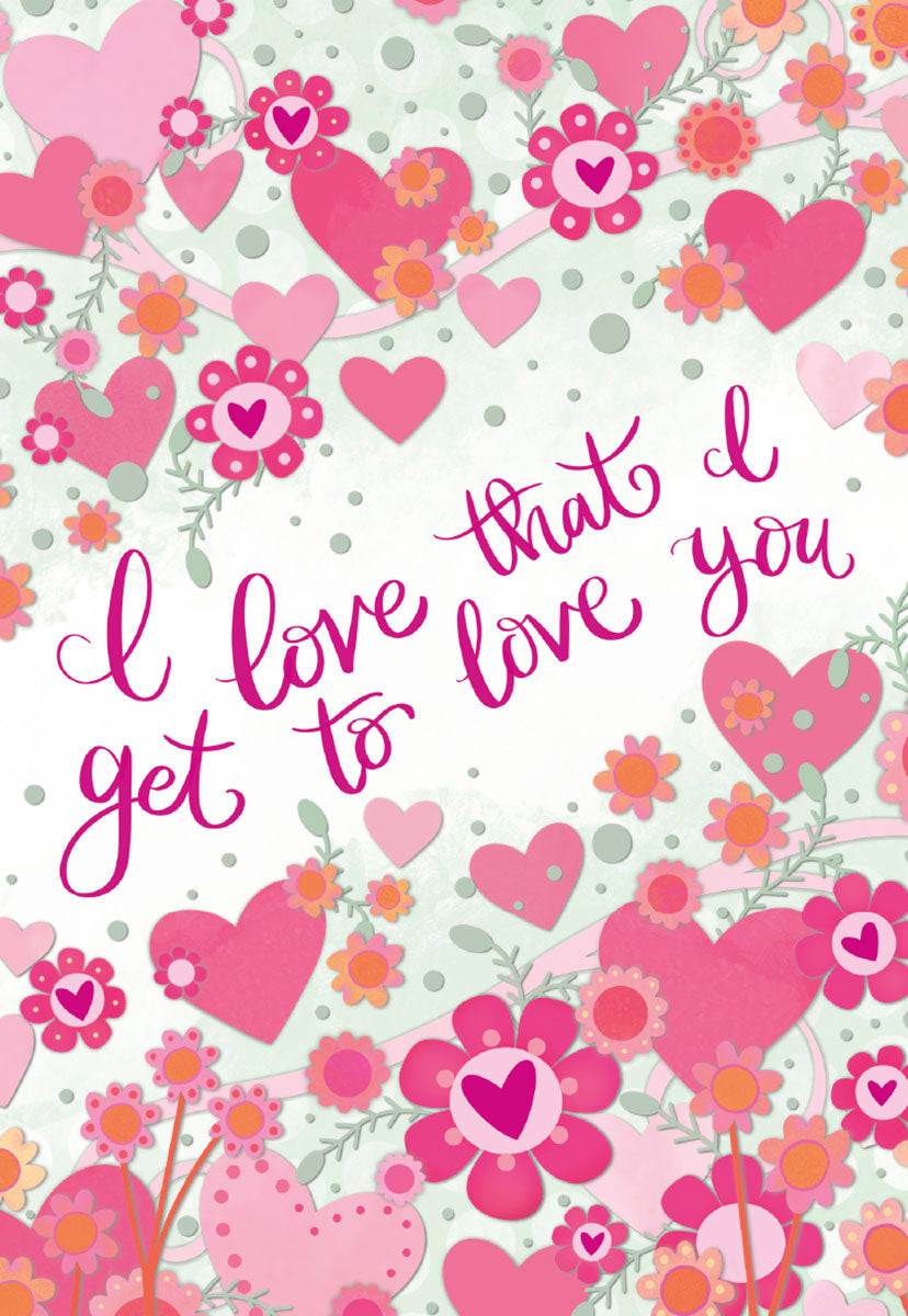 Romantic greeting card front with a pattern of pink hearts, blossoms, and green vines on a soft speckled background. Features the elegant fuchsia script 'I love that I get to love you'.
