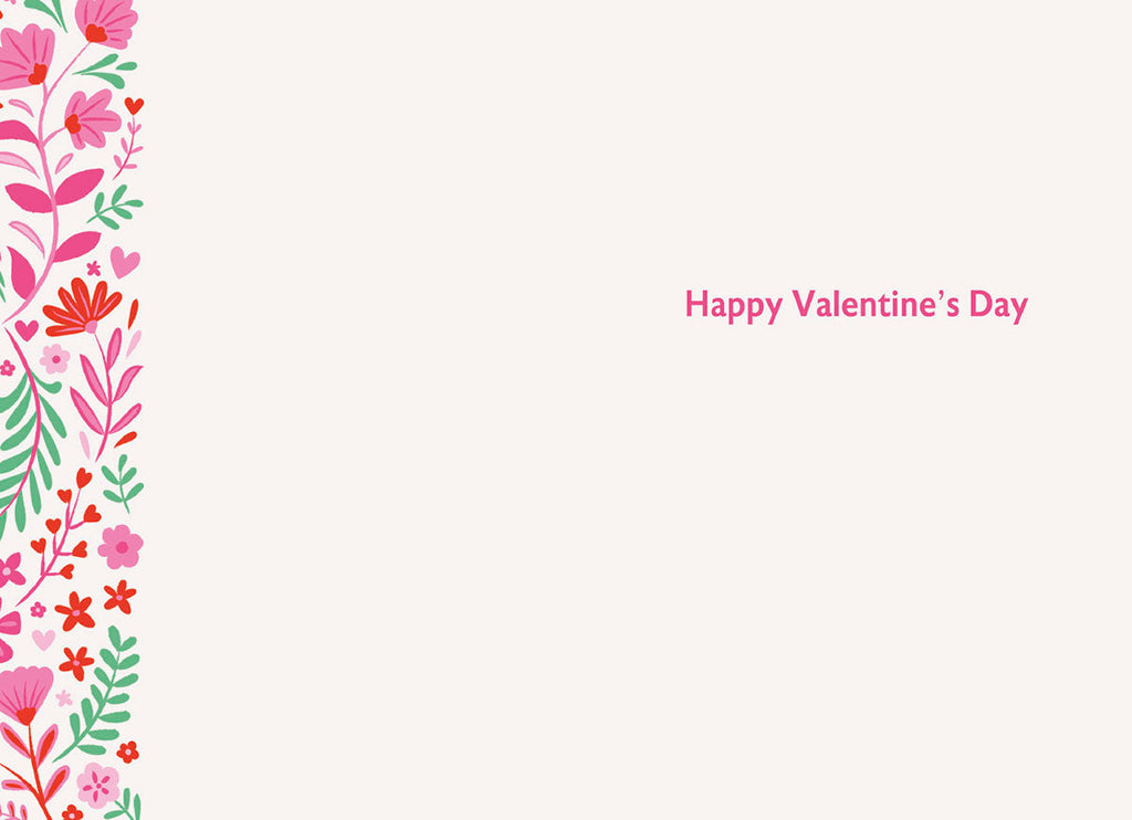 Interior view of a heartfelt Valentine's Day card with 'Happy Valentine's Day' in pink script, accented by a floral border on the left with pink and red blossoms and green foliage, offering ample space for a personalized message.
