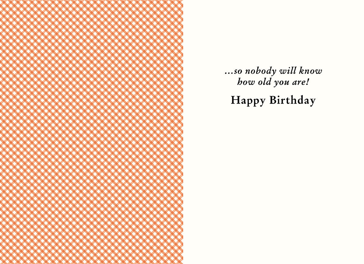 Inside of a lighthearted greeting card showing an orange gingham pattern on the left and white space on the right, revealing the humorous punchline '...so nobody will know how old you are! Happy Birthday' for a fun friend's card.