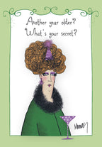 Sassy cartoon woman with big hair, purple party hat, and martini glass on a green-bordered birthday card. Text: 'Another year older? What's your secret?'