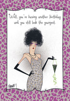 Funny greeting card featuring a stylish cartoon woman with a large afro, sunglasses, leopard print dress, and long black gloves, jokingly saying 'you still look the youngest', set against a purple leopard print background. Ideal for a female friend's birthday.