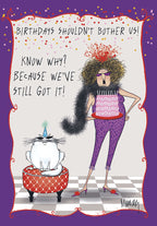 Sassy woman in purple jumpsuit holding a pink celebration cake next to a funny cat in a party hat. Vibrant illustration for a funny occasion card, with text "We've Still Got It!"