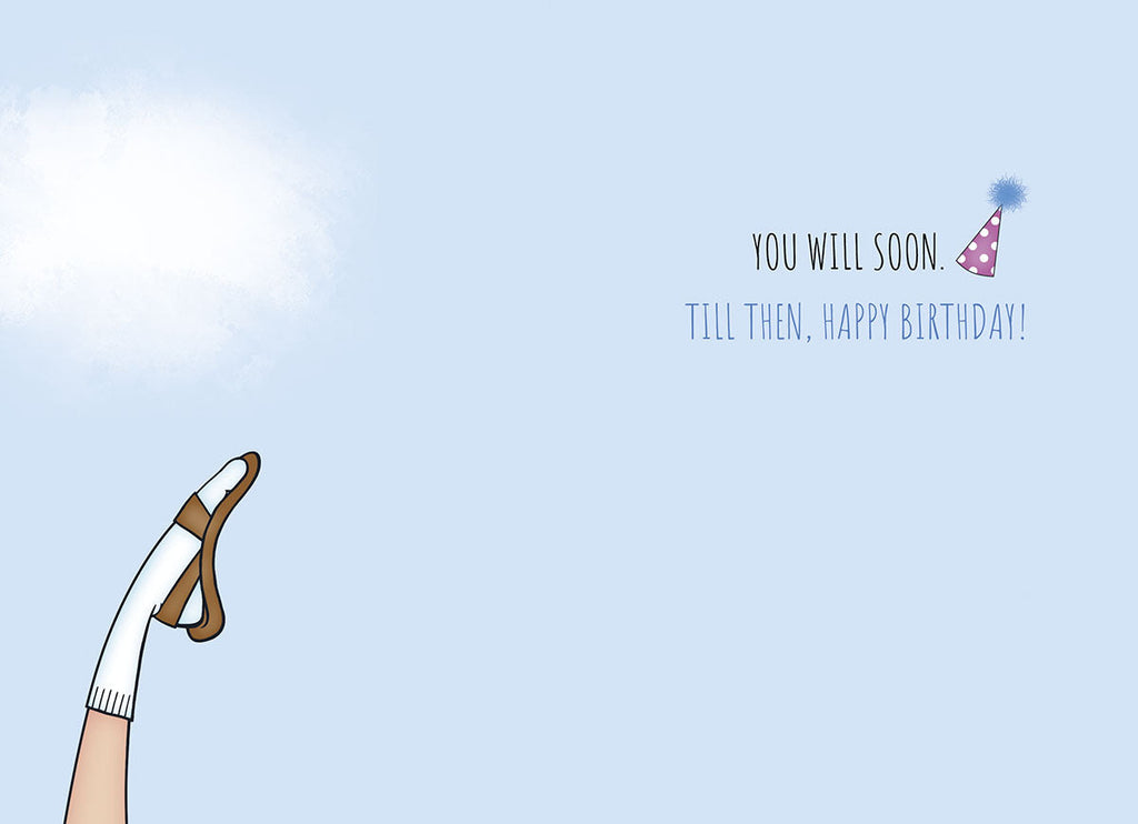 Inside view of a humorous birthday card showing a leg with a sock and sandal, a party hat, and the playful message 'YOU WILL SOON. TILL THEN, HAPPY BIRTHDAY!', ideal for an older man.
