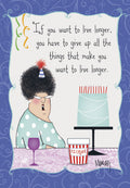 Front of a funny birthday greeting card featuring a cartoon woman with curly hair, wearing a party hat and glasses. She's sitting at a table with a slice of blue cake, a tub of ice cream, and a glass of wine. The text reads: 'If you want to live longer, you have to give up all the things that make you want to live longer.' The background is a decorative blue swirl pattern, perfect for an adult birthday.