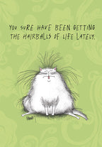 Funny cat encouragement greeting card front with a fluffy white cat having a bad hair day, sticking its tongue out, and text 'YOU SURE HAVE BEEN GETTING THE HAIRBALLS OF LIFE LATELY.' on a green patterned background.