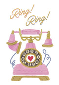 Front of a lighthearted greeting card featuring a pink vintage rotary telephone with gold accents and the words 'Ring! Ring!' in playful script. A red heart is centered on the phone dial.