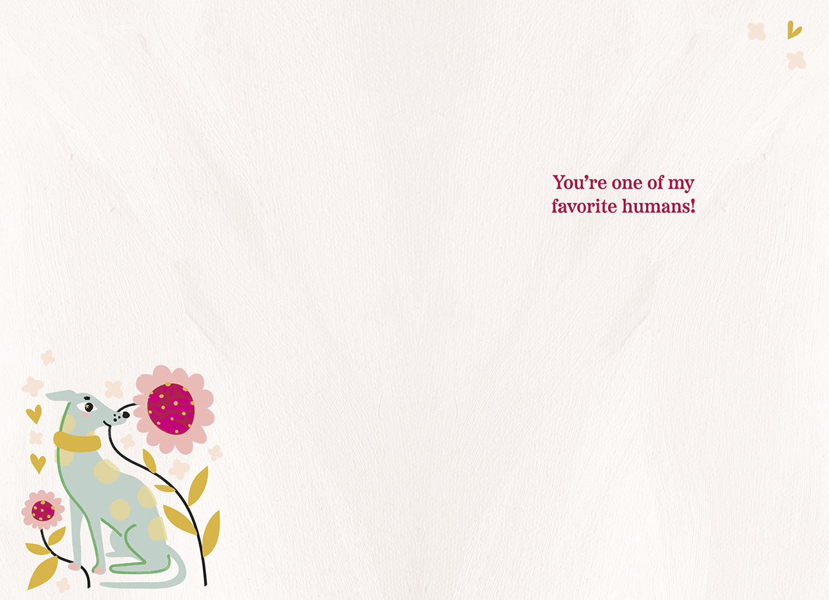 Inside view of a friendship greeting card with a cute blue dog and pink flower illustration, displaying the warm message 'You're one of my favorite humans!'.