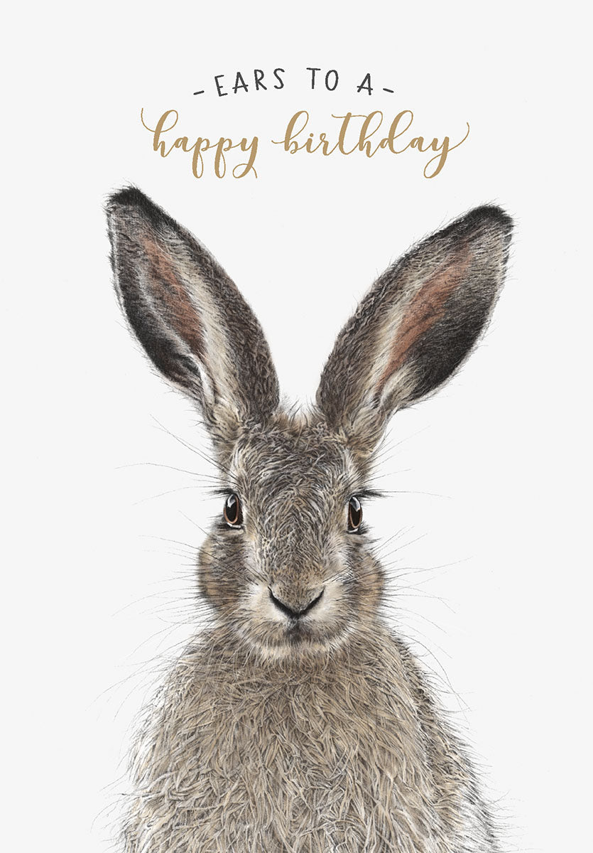 Close-up of an adorable brown hare with large ears and whiskers, looking directly ahead, against a white background with gold cursive text 'Ears to a happy birthday' above its head. Perfect for a cute greeting.