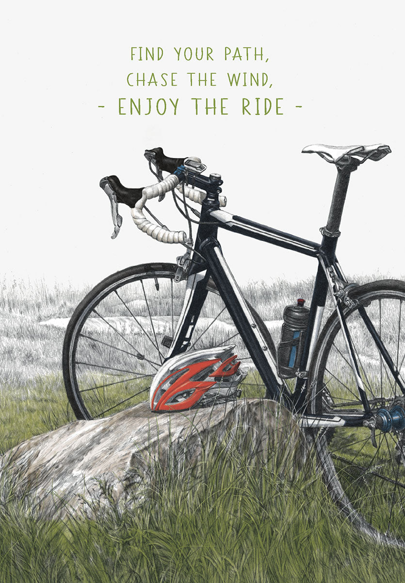 Illustrated greeting card featuring a black road bicycle leaning against a rock in a grassy field, with a red helmet beside it. Text reads: 'FIND YOUR PATH, CHASE THE WIND, - ENJOY THE RIDE -'. Ideal for him, a friend, or any cycling enthusiast.