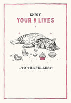 Funny greeting card front featuring a content tabby cat sound asleep amidst eaten cupcake wrappers and untouched cupcakes, with text 'ENJOY YOUR 9 LIVES ...TO THE FULLEST!' in a pink border, perfect for cat lovers.