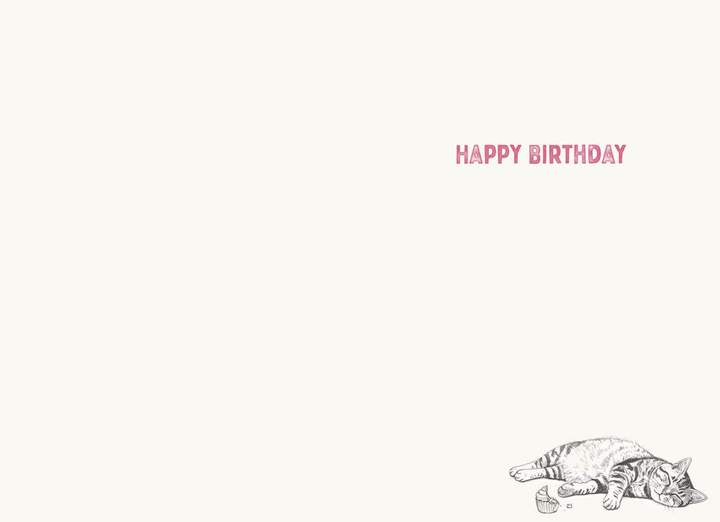 Inside of a humorous greeting card, light background with 'HAPPY BIRTHDAY' text at the top right and a small illustration of a sleeping tabby cat next to a cupcake wrapper at the bottom right, ready for a personalized message.