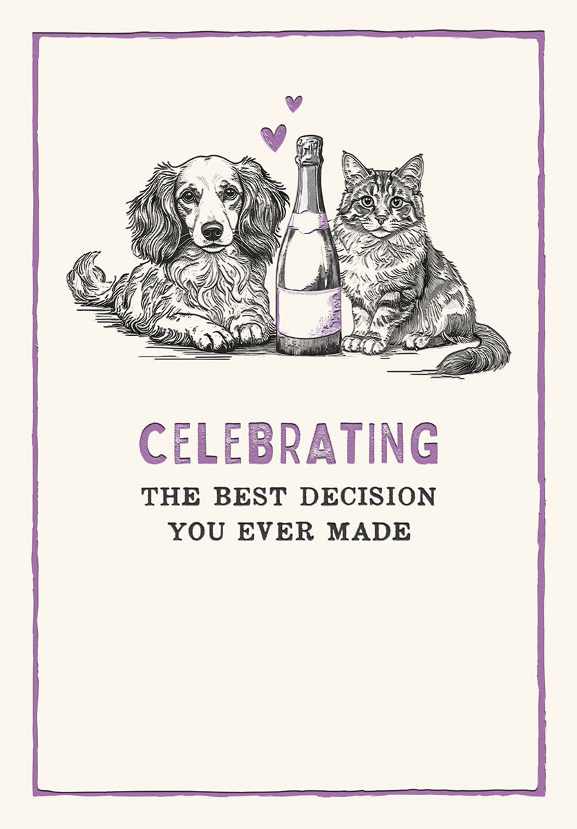 Front of a cute anniversary greeting card featuring a black and white sketch illustration of a fluffy dog and a tabby cat sitting next to a champagne bottle with two purple hearts. The text reads: 'CELEBRATING THE BEST DECISION YOU EVER MADE'.