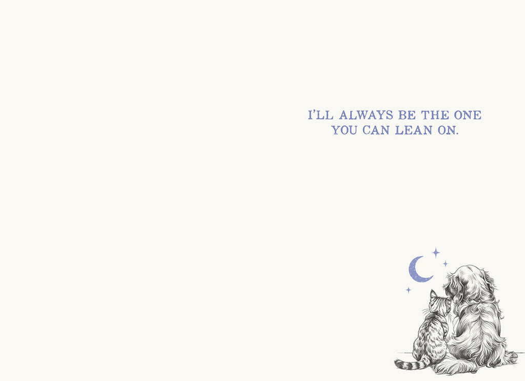 Inside of an encouragement greeting card for a friend, featuring a small matching hand-drawn illustration of a dog and cat under a crescent moon in the bottom right corner. The main text reads 'I'LL ALWAYS BE THE ONE YOU CAN LEAN ON.' in blue, reassuring script against a soft cream background. This image highlights the heartfelt, supportive message intended for a woman needing comfort during difficult times.