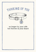 Front of pet memorial greeting card featuring a dog collar with paw print tag and text 'Thinking of You, no longer by your side but forever in your heart'.